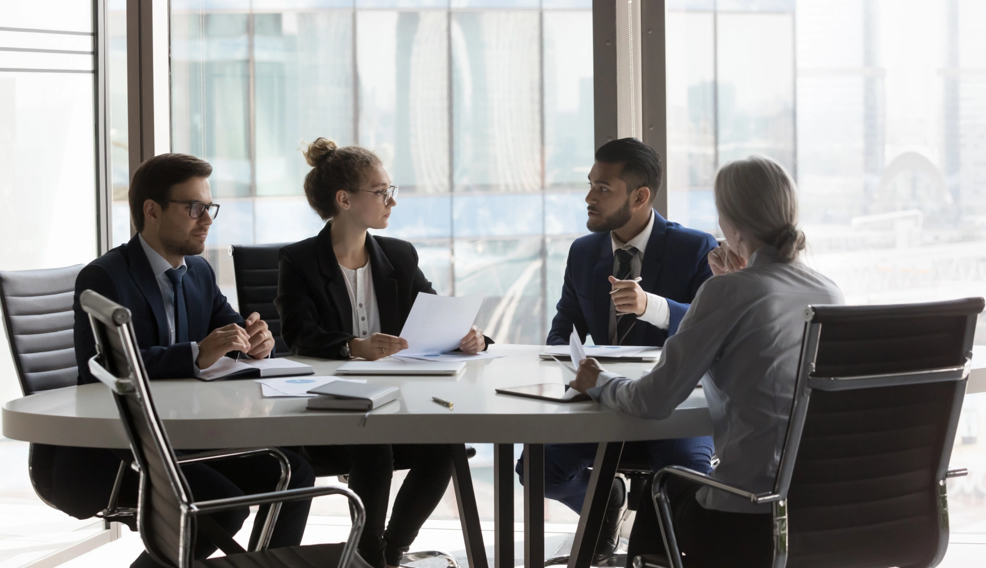 A group of people sitting at a table with papers.