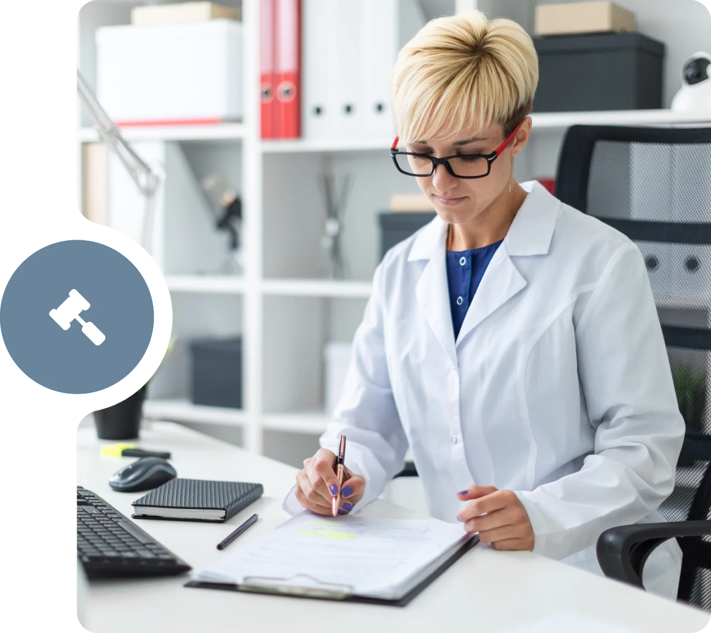 A woman in lab coat writing on paper at desk.