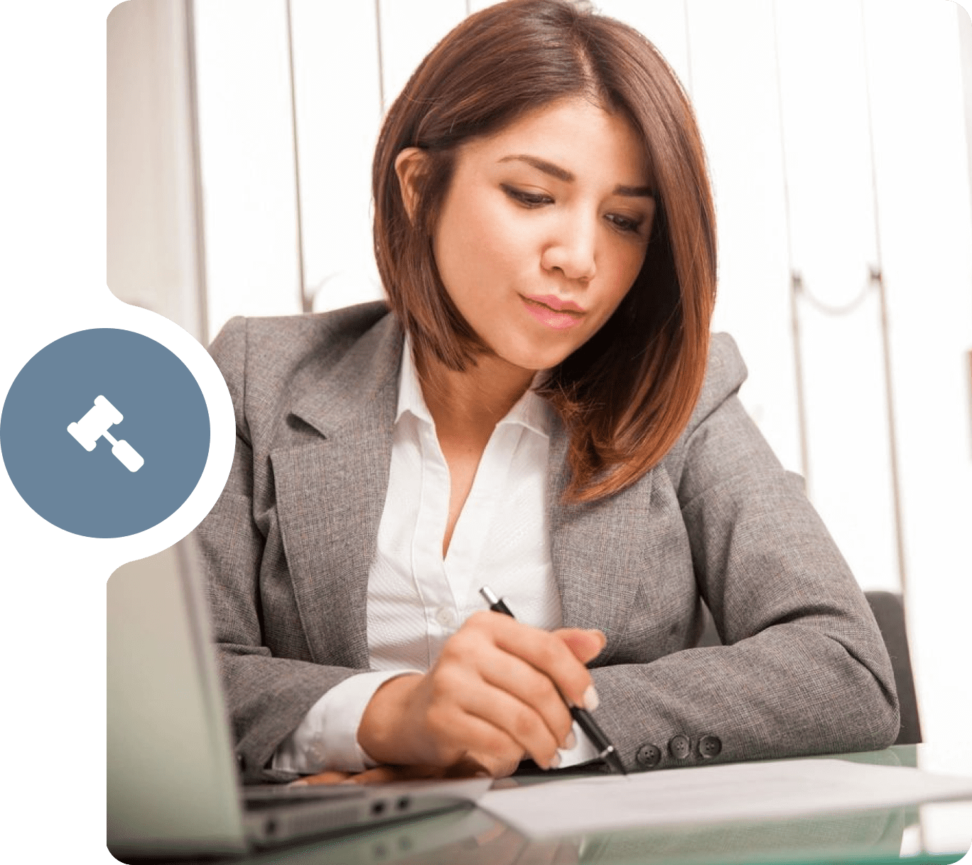 A woman sitting at her desk writing on paper.